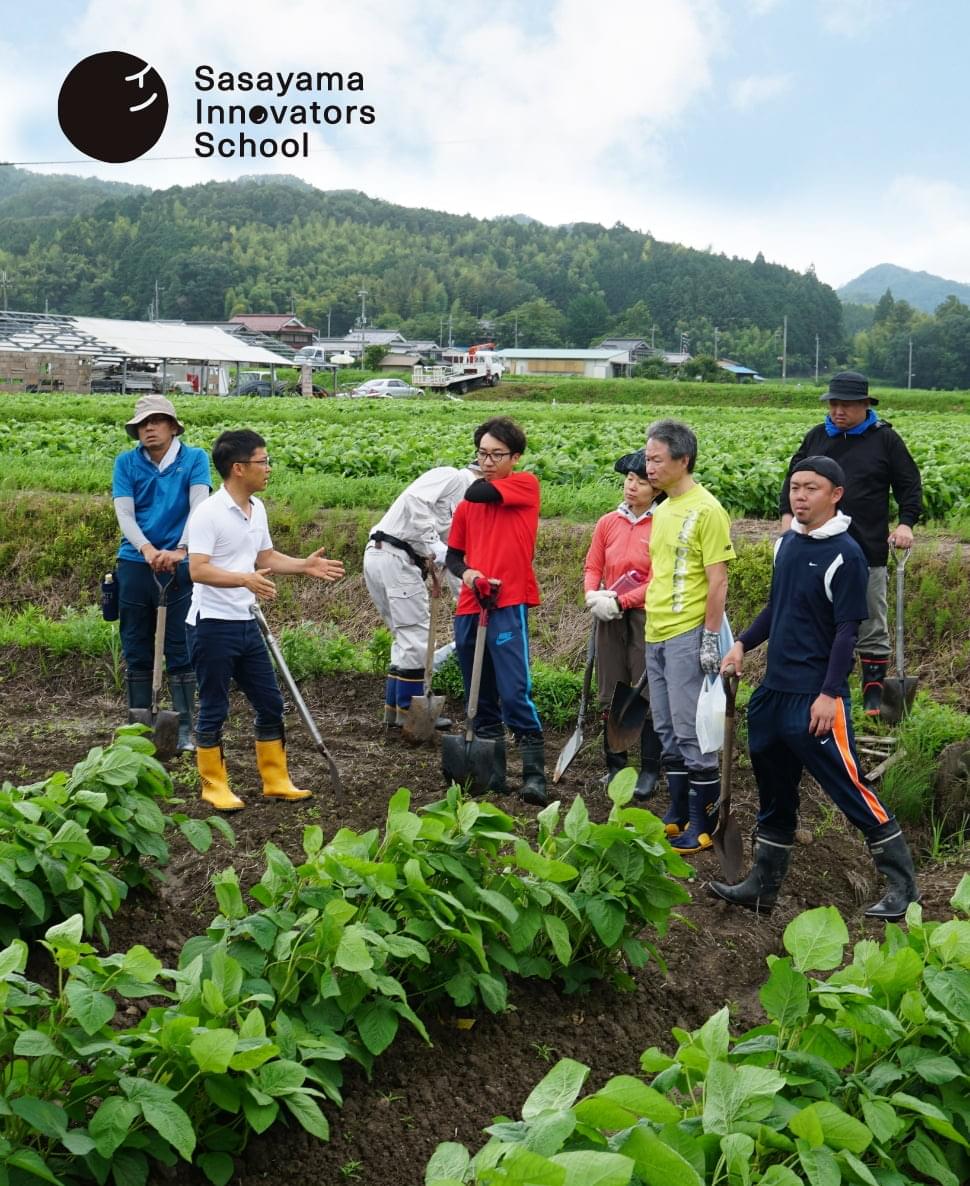 スクール生が農従事者と一緒に畑で作業をしている様子